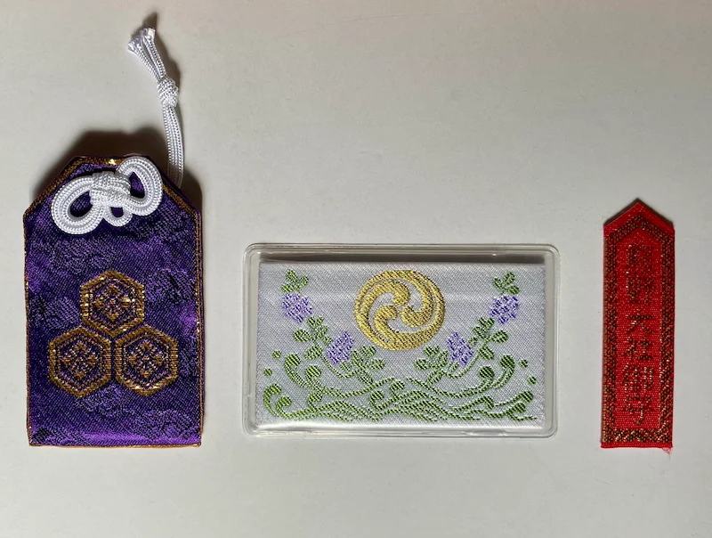 Three types of omamori (Japanese protective charms): a traditional pouch type, a card type, and a small body omamori.